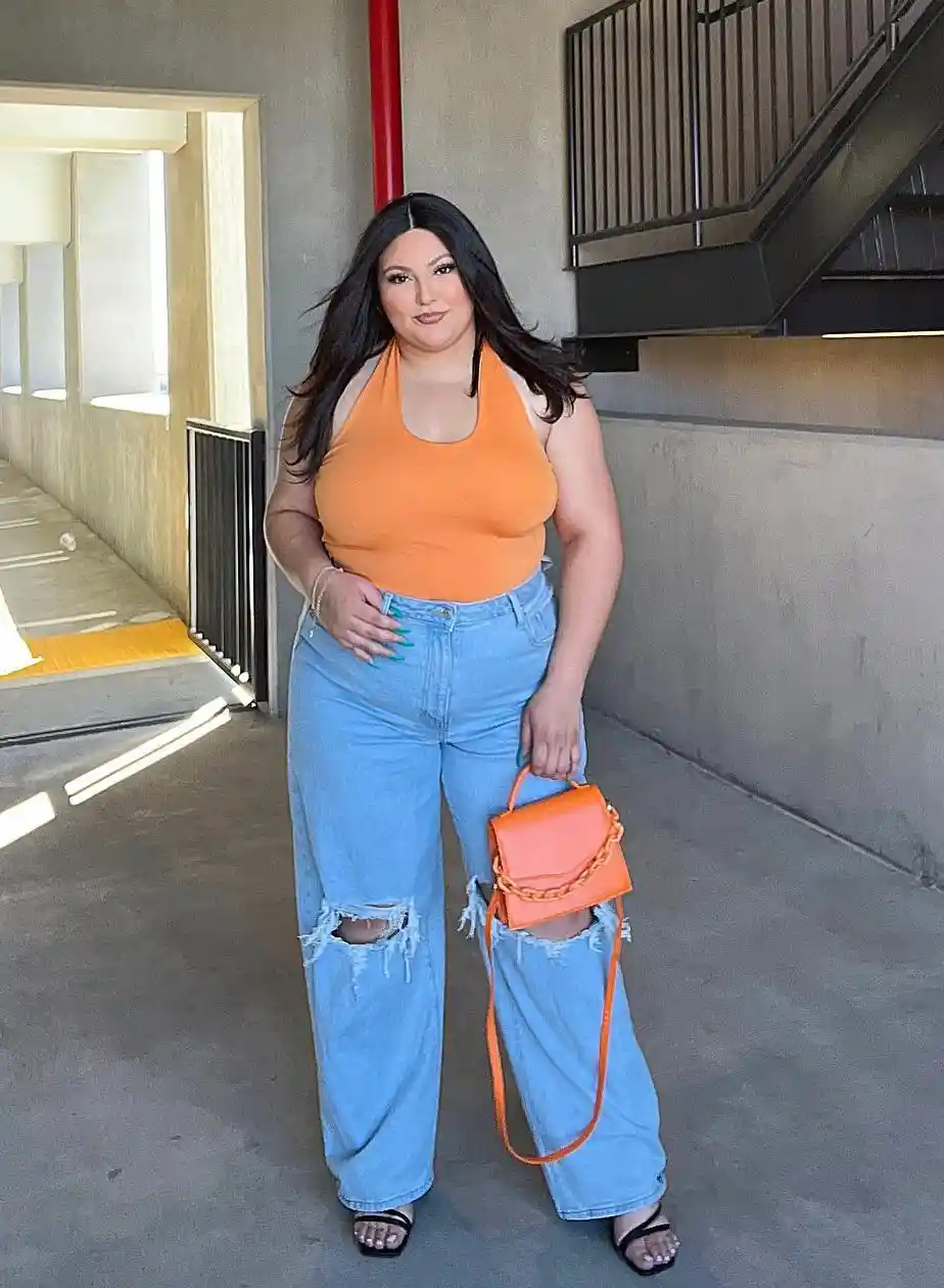 Orange halter top with ripped wide-leg jeans