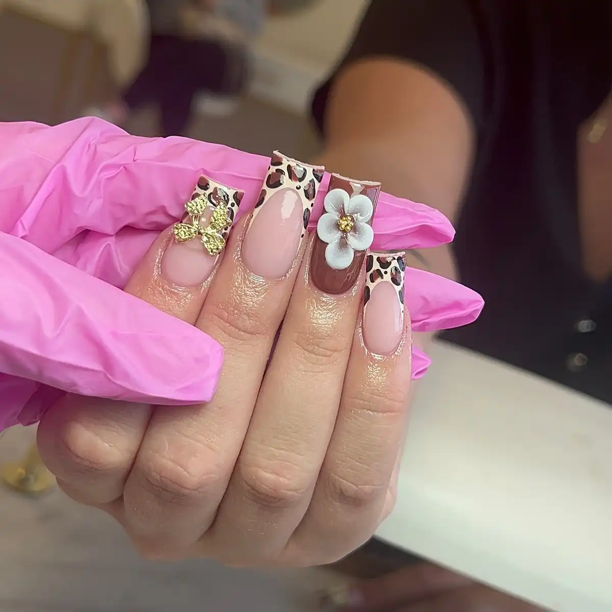 Leopard French tips with a white 3D flower and gold butterfly charm
