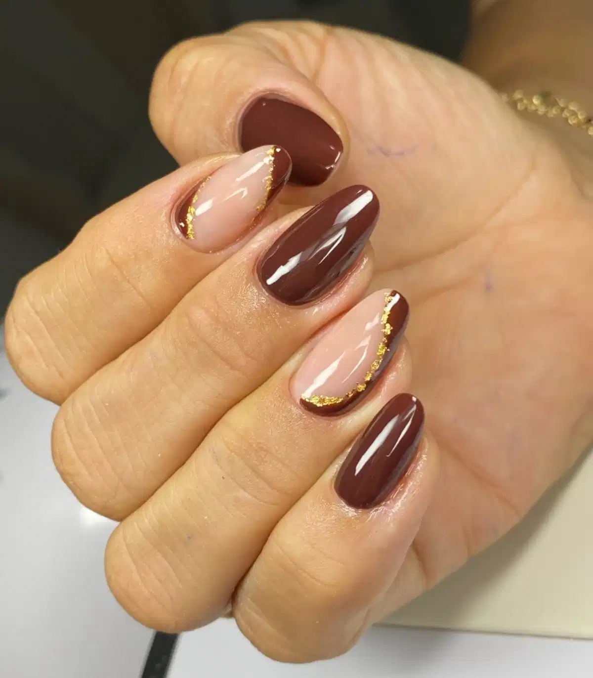 Deep brown solids with nude nails edged in gold flecks