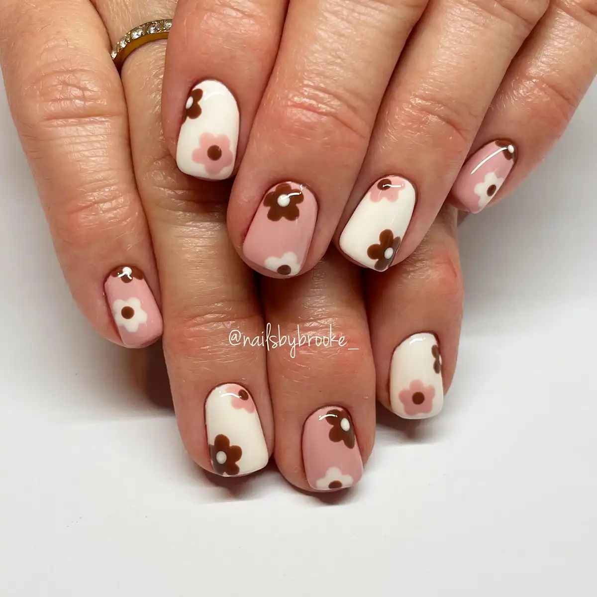 Pale pink and cream nails with simple brown-and-pink flowers