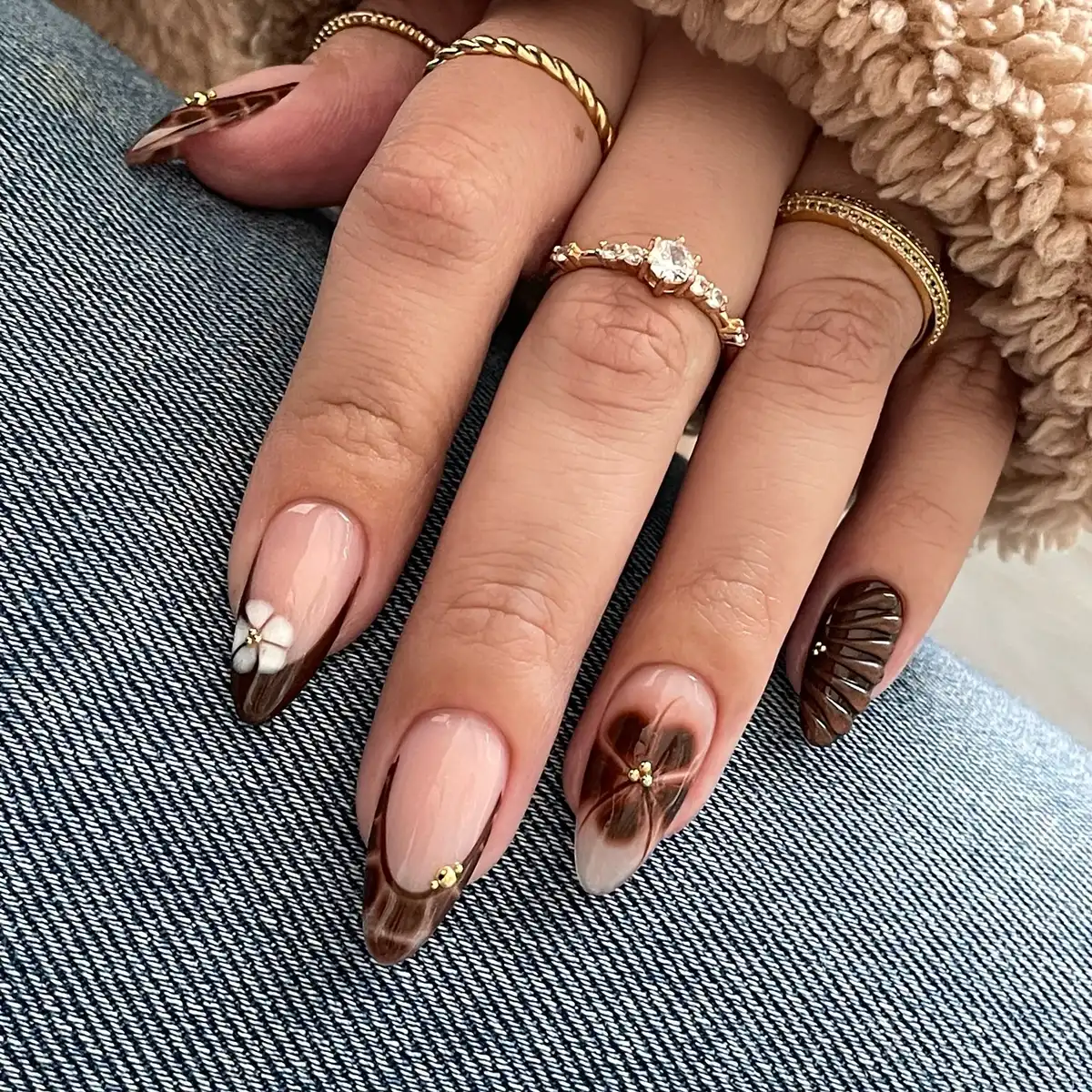 Brown French tips with marbling and floral accents