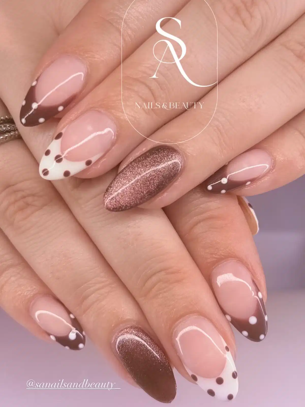 Brown-and-white dotted French tips with sparkly accent nails