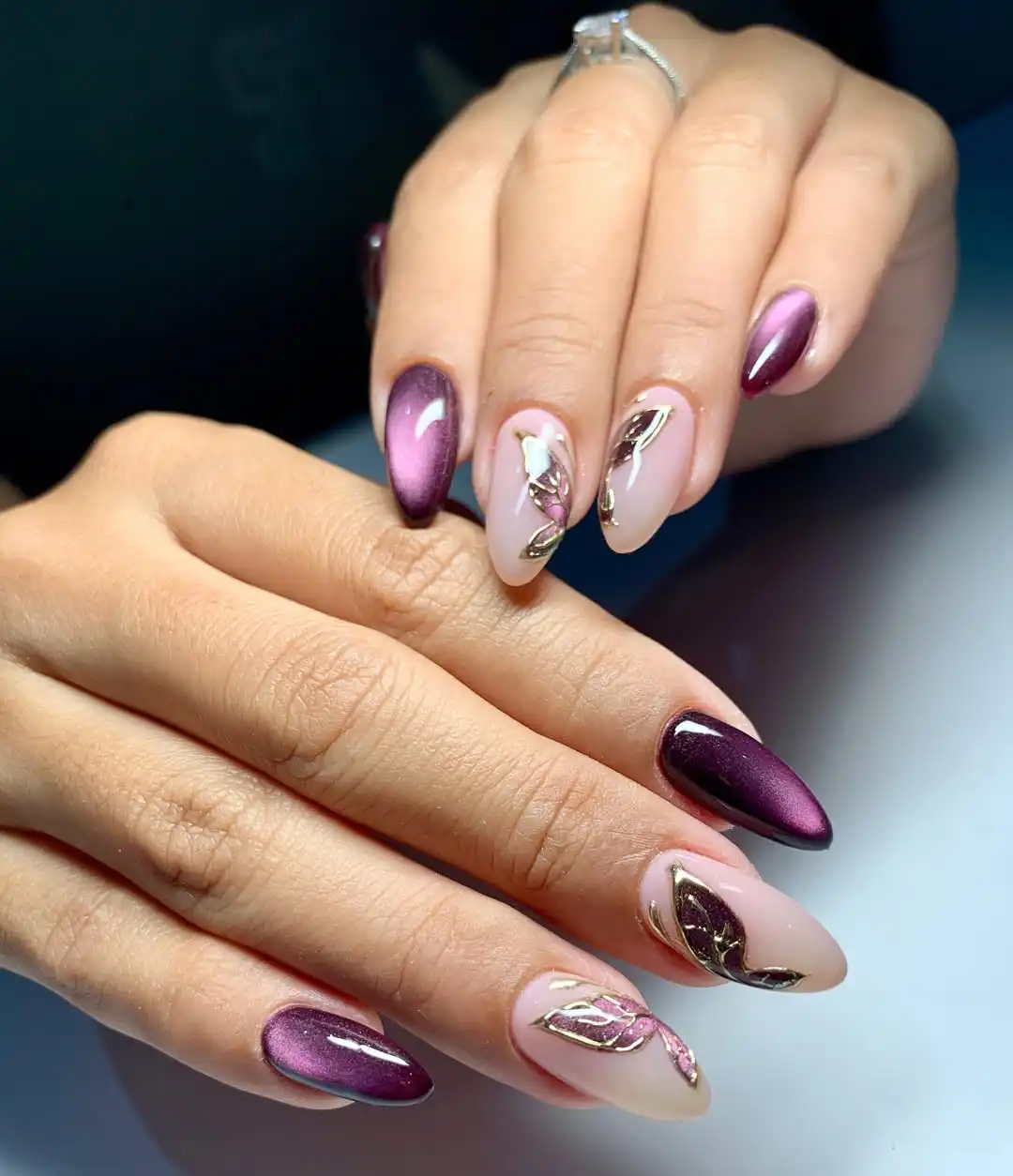Metallic purple and nude nails with gold leaf-outline detailing
