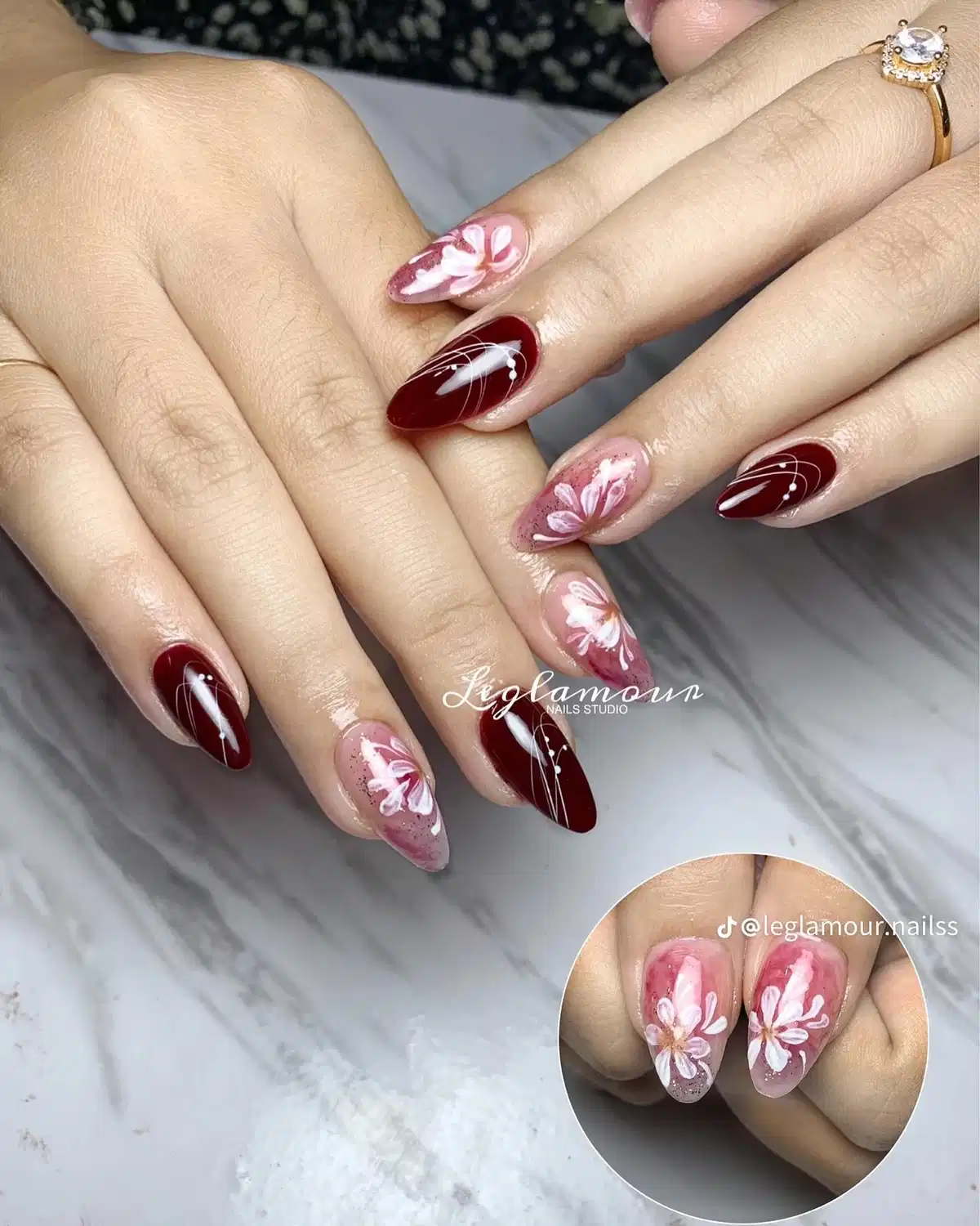 Maroon line art with pink floral accent nails