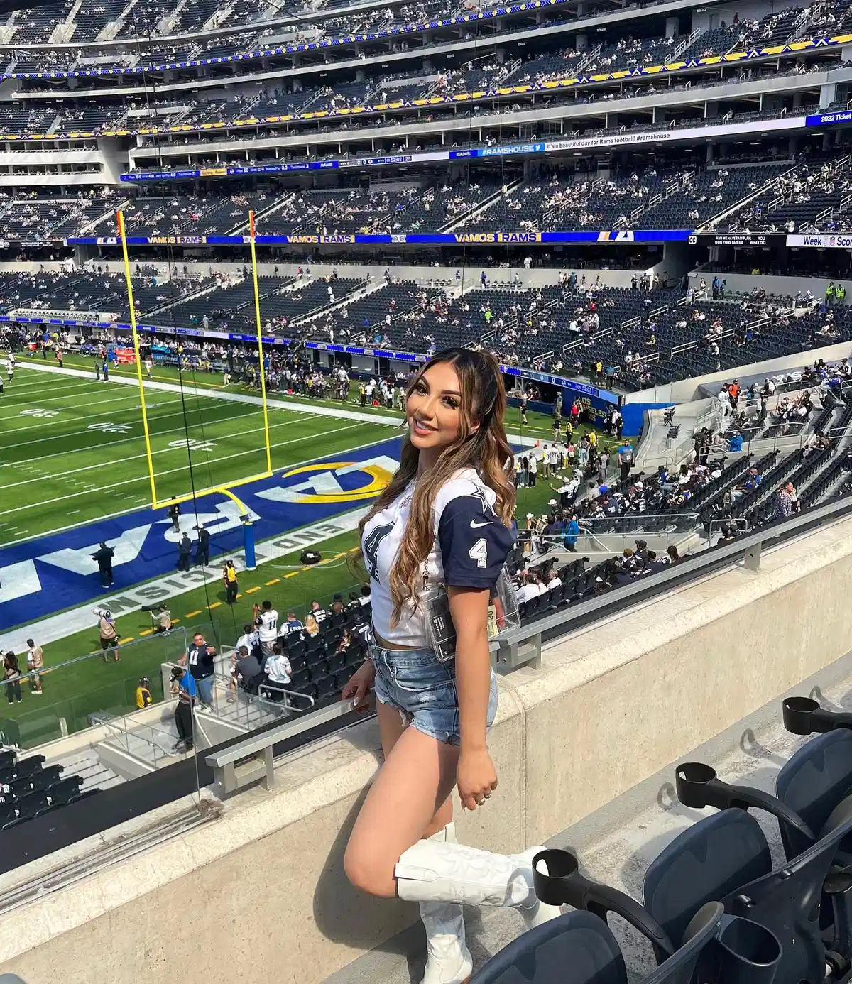 White-and-navy jersey with denim shorts and white boots