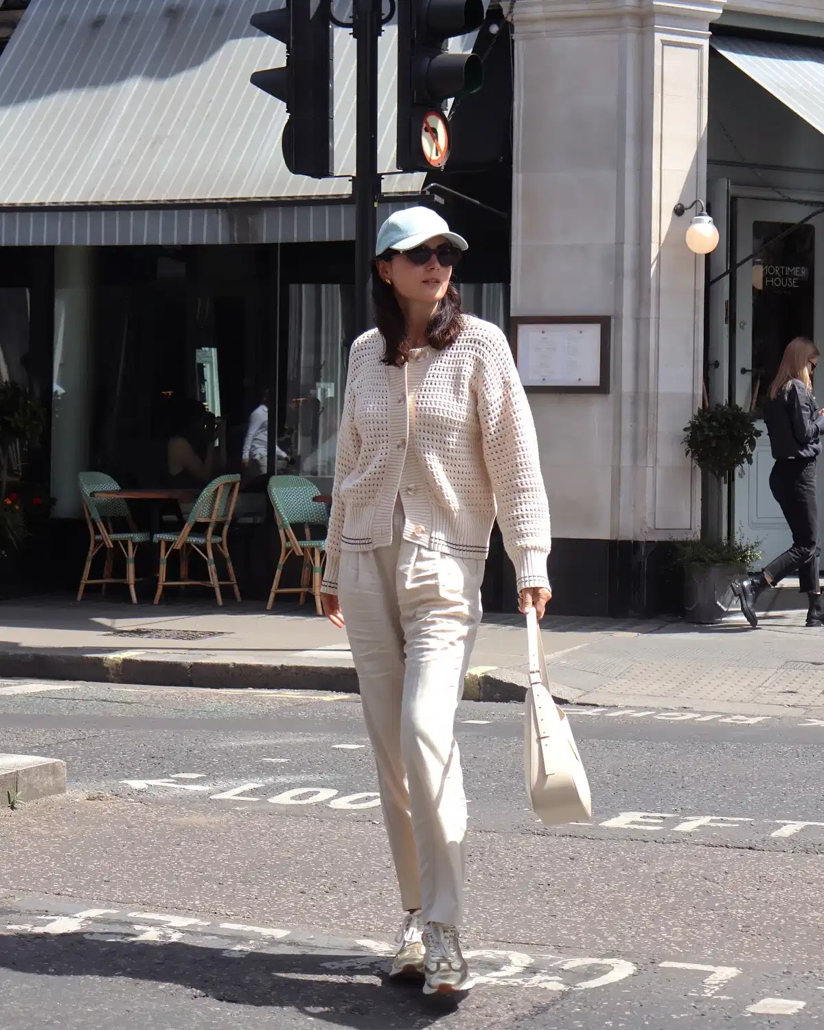 Cream openwork cardigan with beige pants and cap