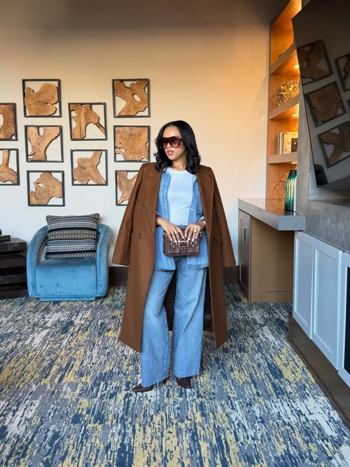 Long brown coat layered over light denim