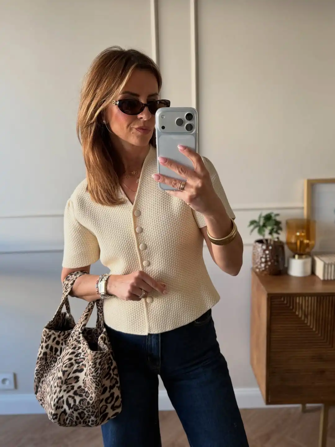 Cream textured top with dark jeans and leopard tote