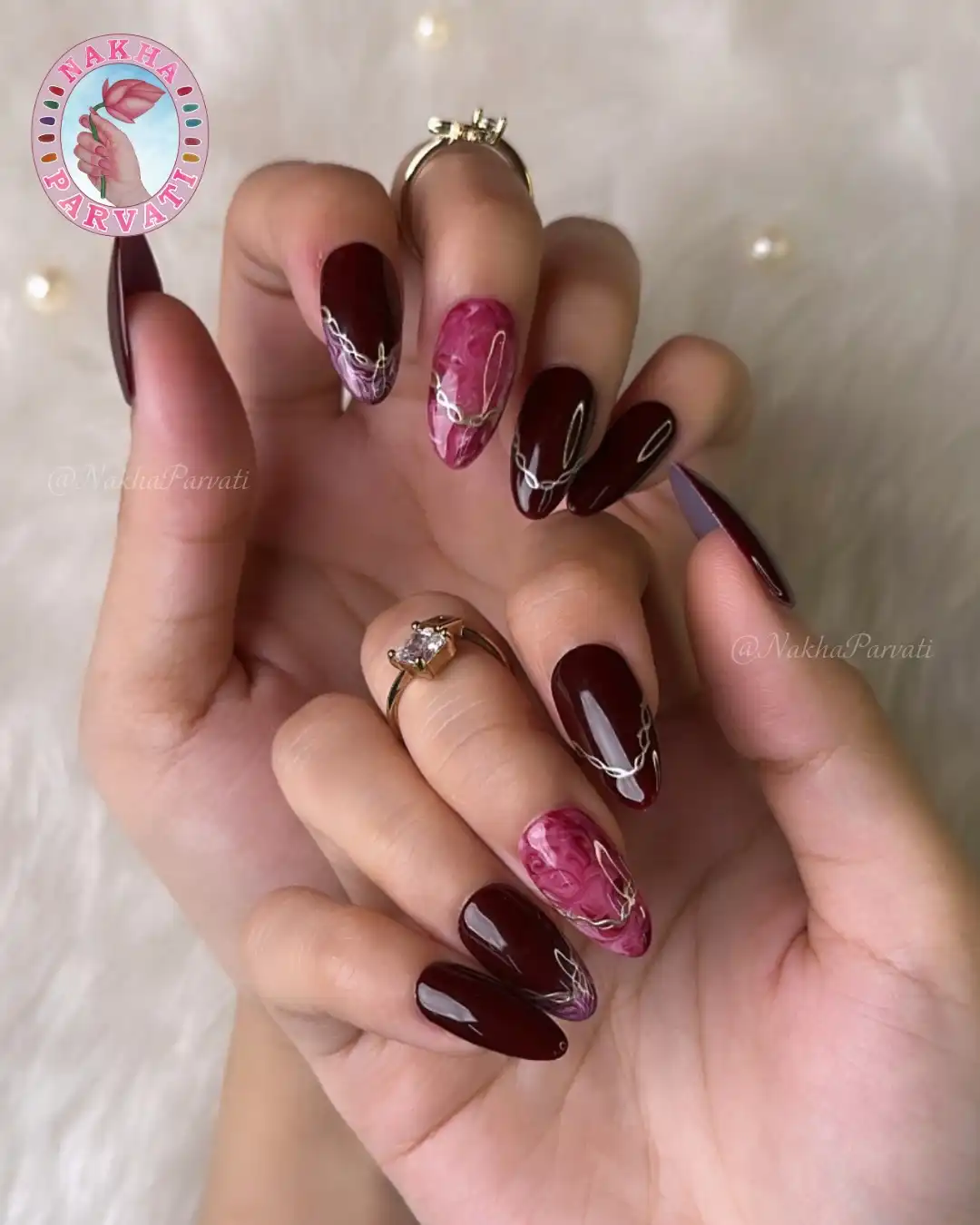 Maroon and pink marbled nails with white looping line art
