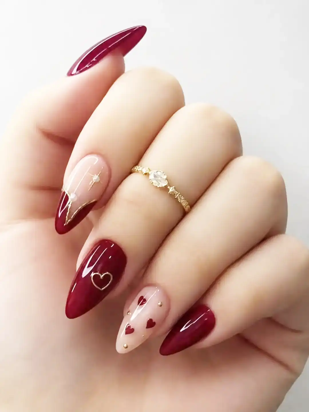 Glossy maroon almonds with nude heart accent and gold details