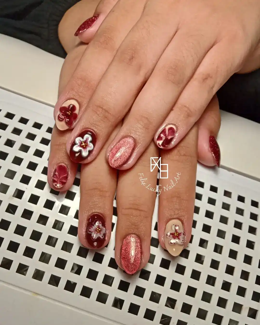 Burgundy and nude nails with 3D florals and rose-gold shimmer accents