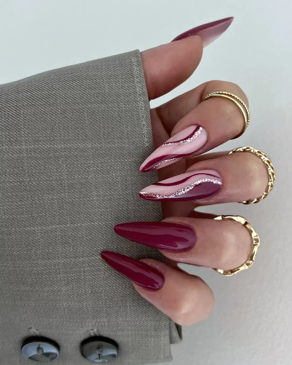 Burgundy stiletto nails with nude-and-wavy silver-glitter accents