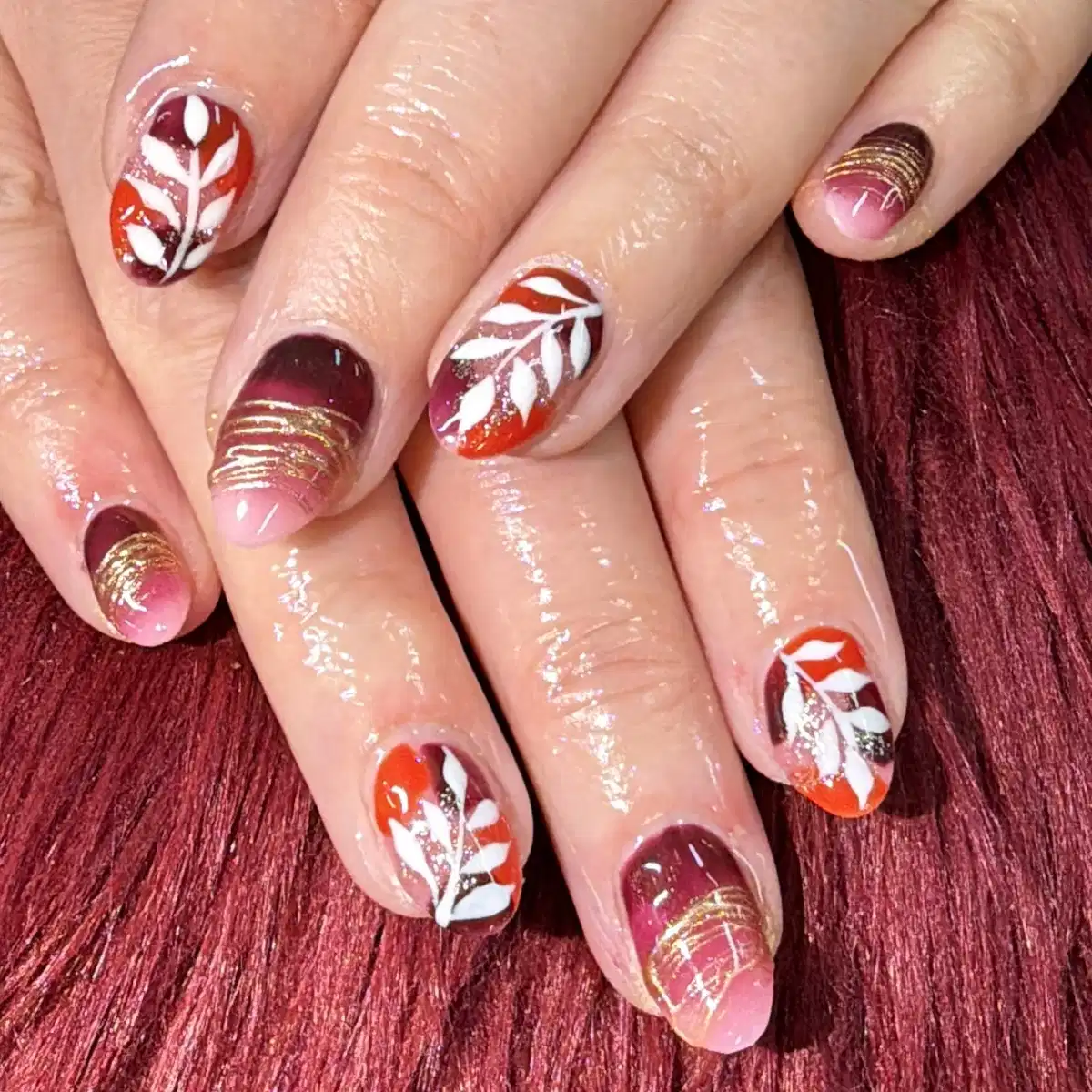 White leaf motifs with maroon and warm gradients