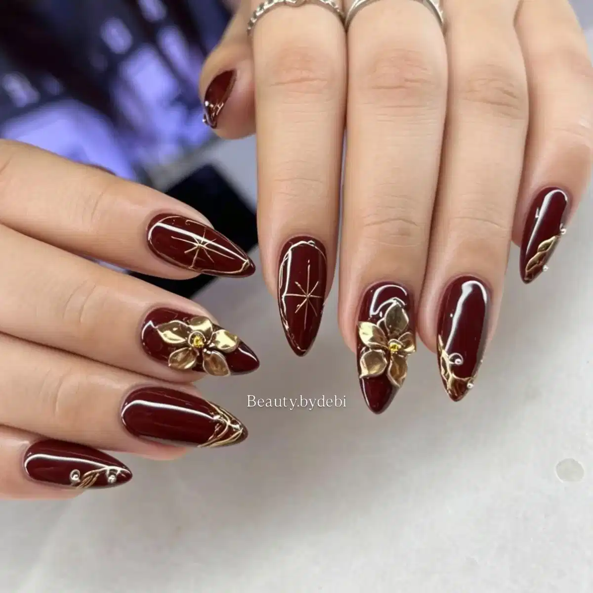 Maroon Almond Nails with Gold 3D Flowers