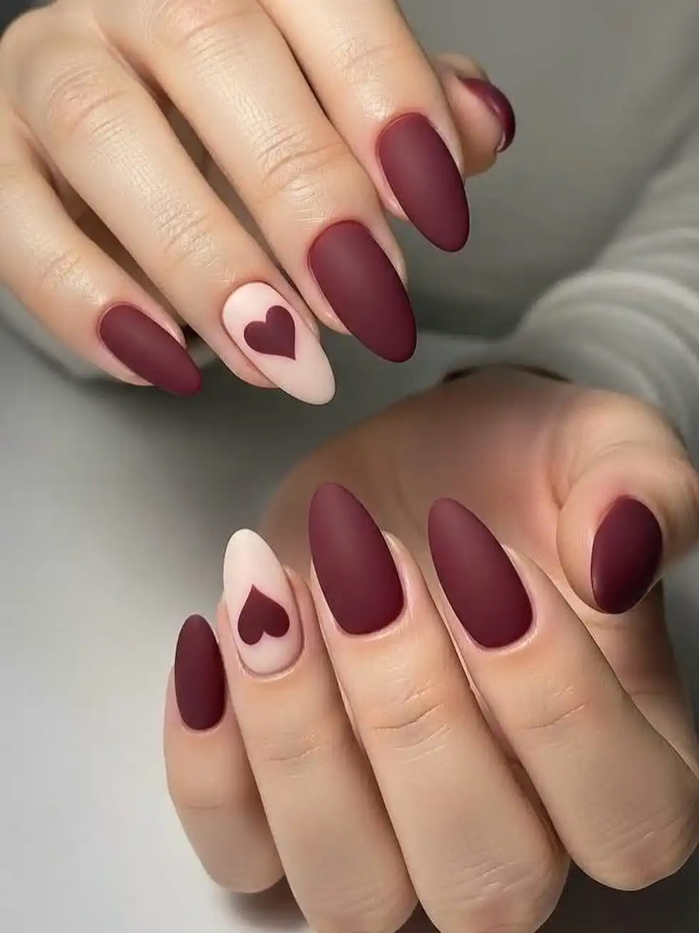 Matte maroon almonds with nude heart accent nails