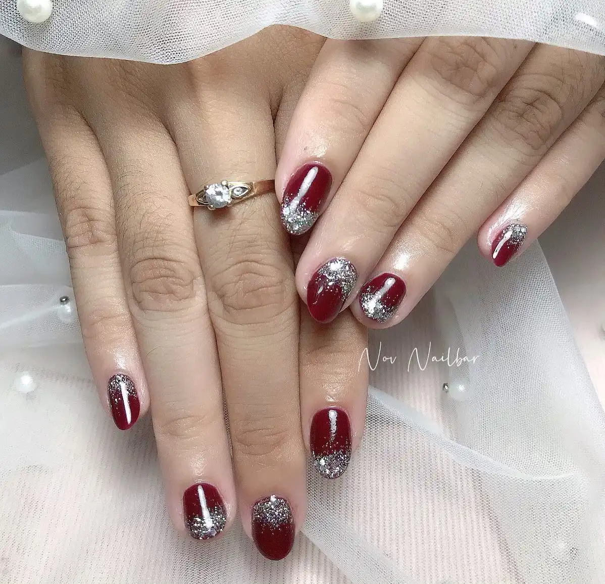 Maroon glossy nails with silver glitter tip gradient