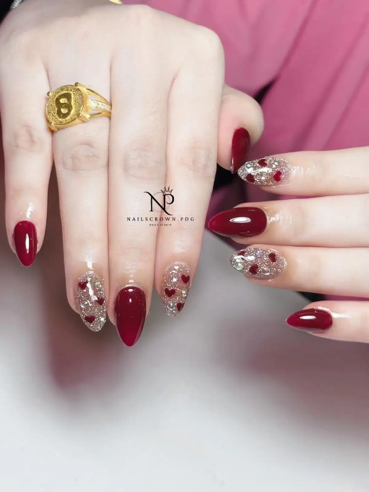 Maroon solids with glitter-and-heart accent nails and rhinestones
