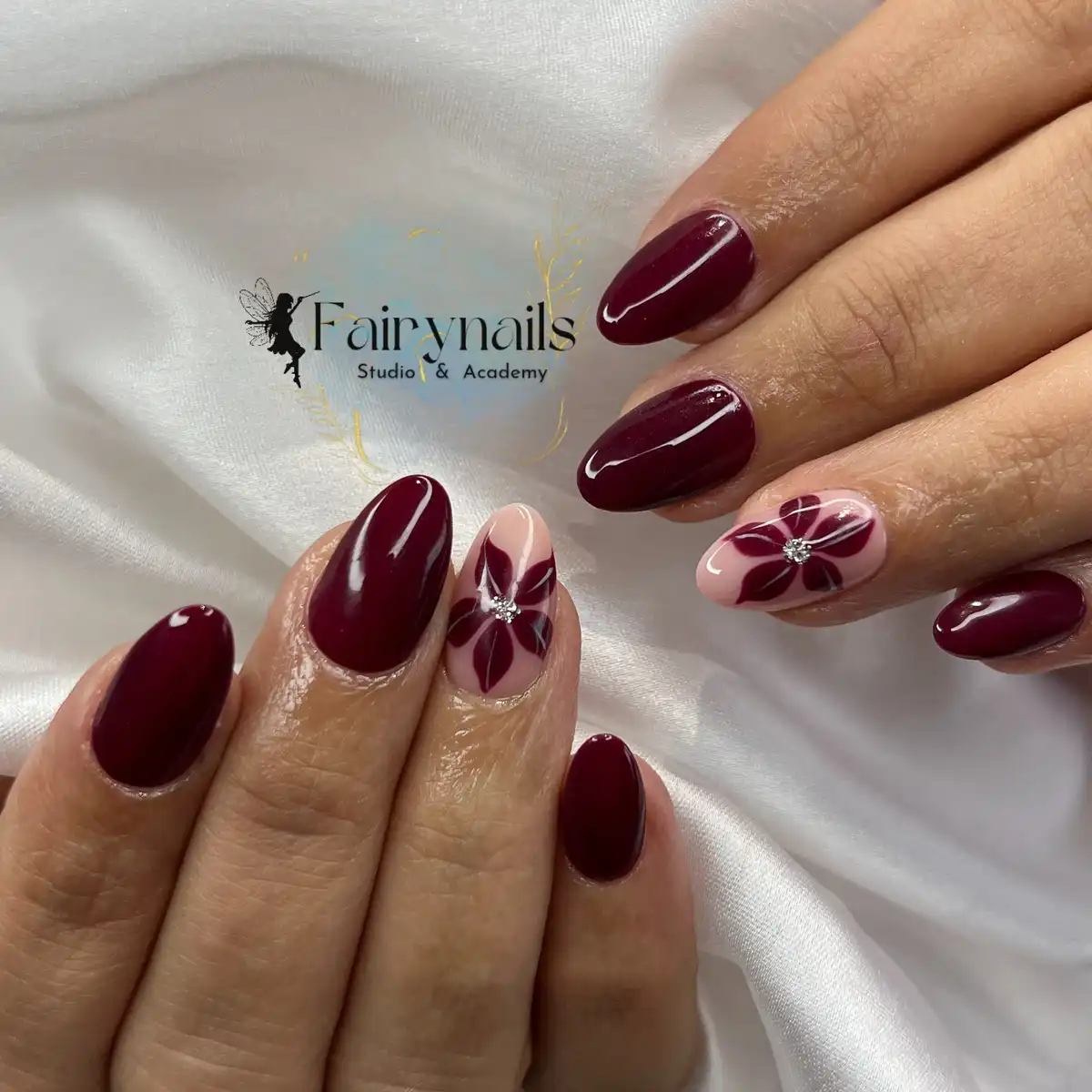Glossy maroon with pale-pink floral accent nails