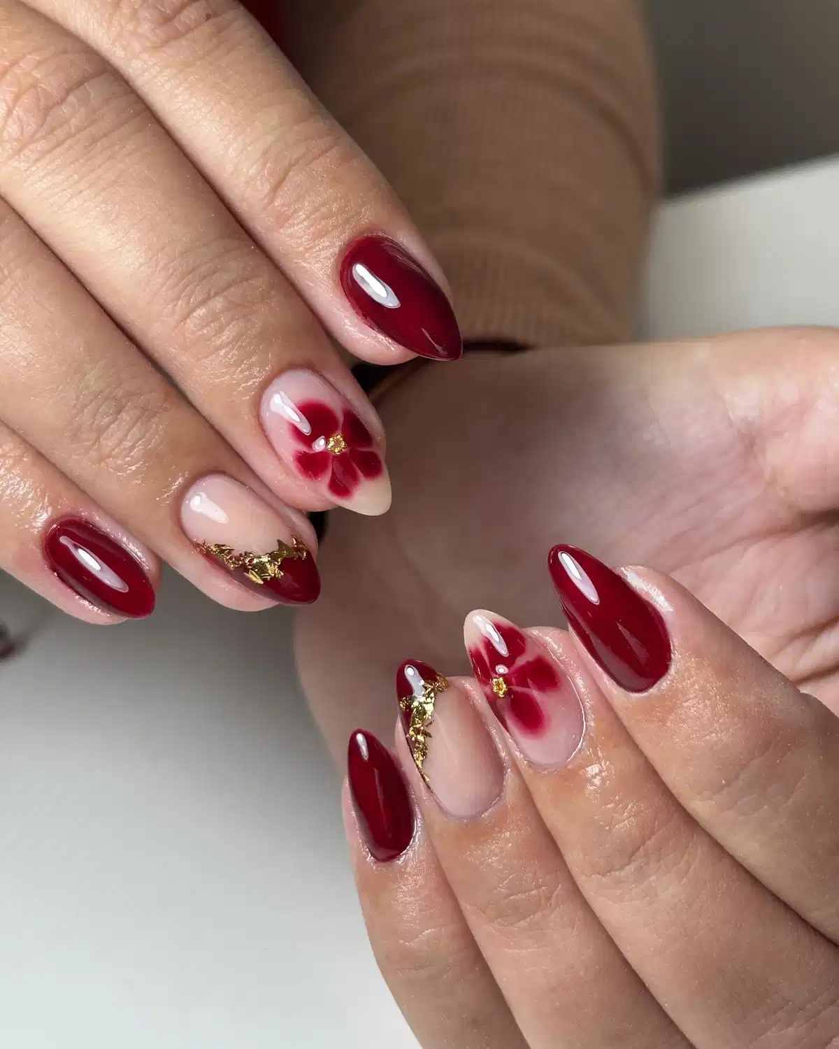 Glossy maroon with nude floral accents and gold flakes