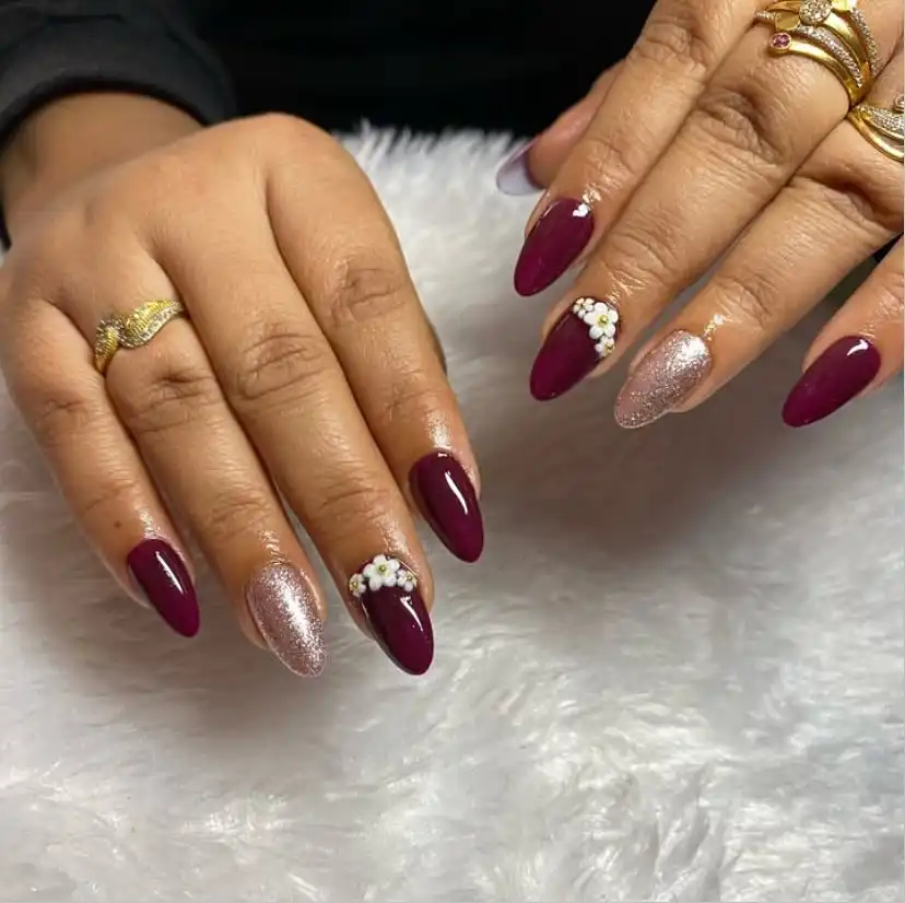 Maroon almond nails with glitter accents and white bead cluster