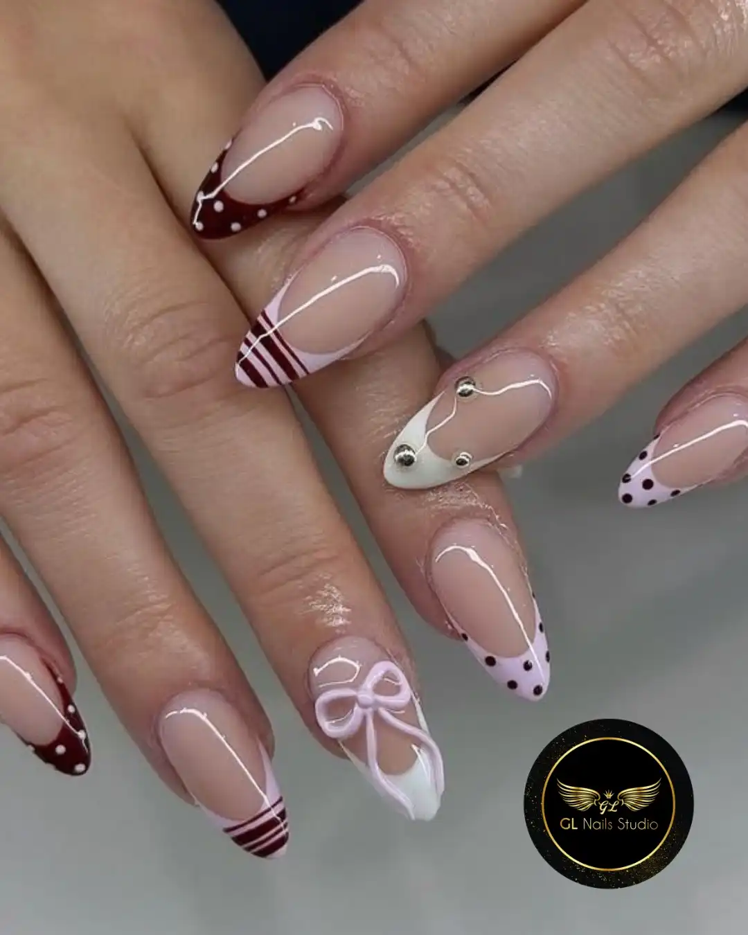 French tip mix: maroon polka dots, stripes, studs, and a raised bow