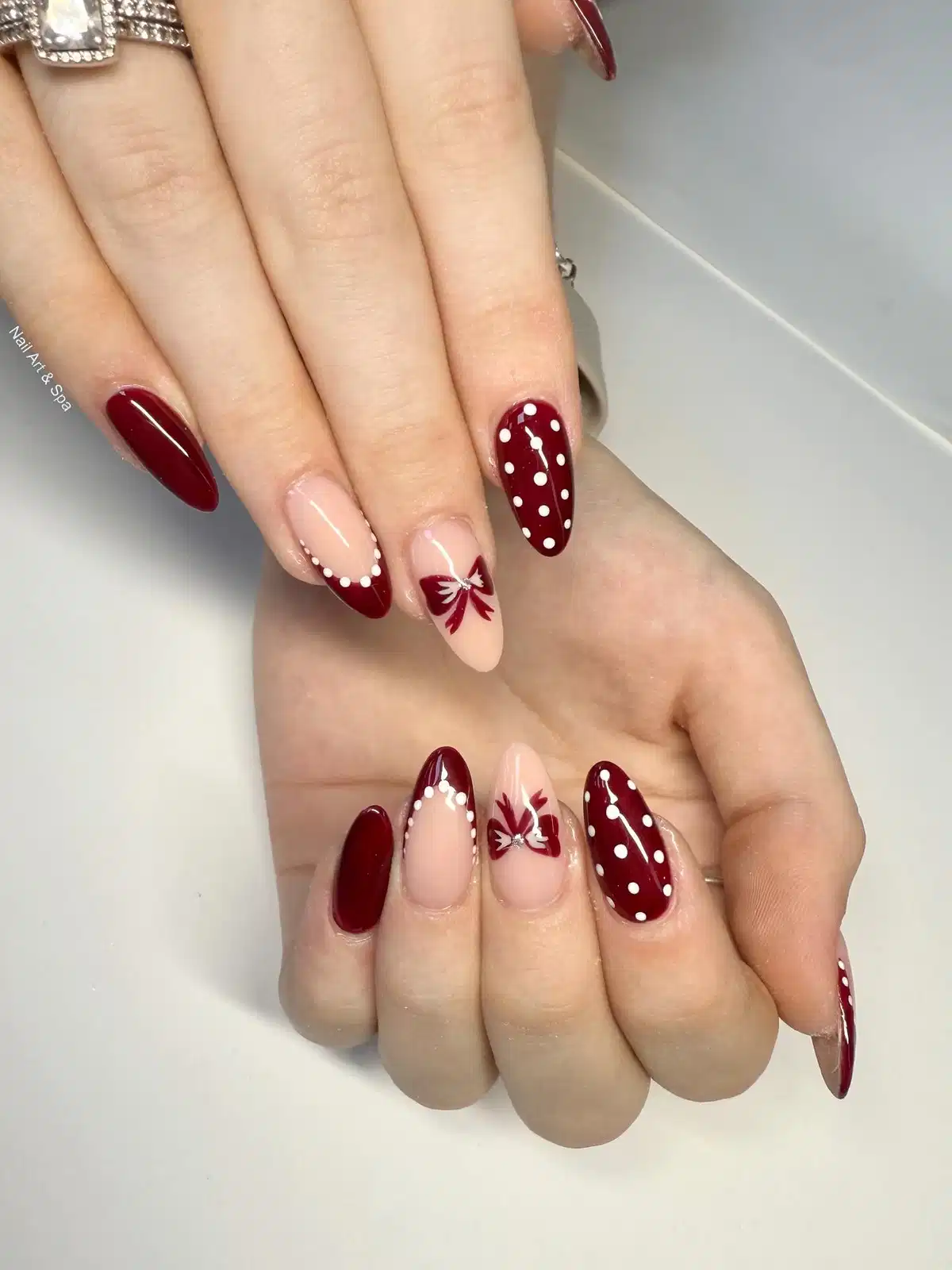 Maroon polka-dot accent with bow art and dotted French tips
