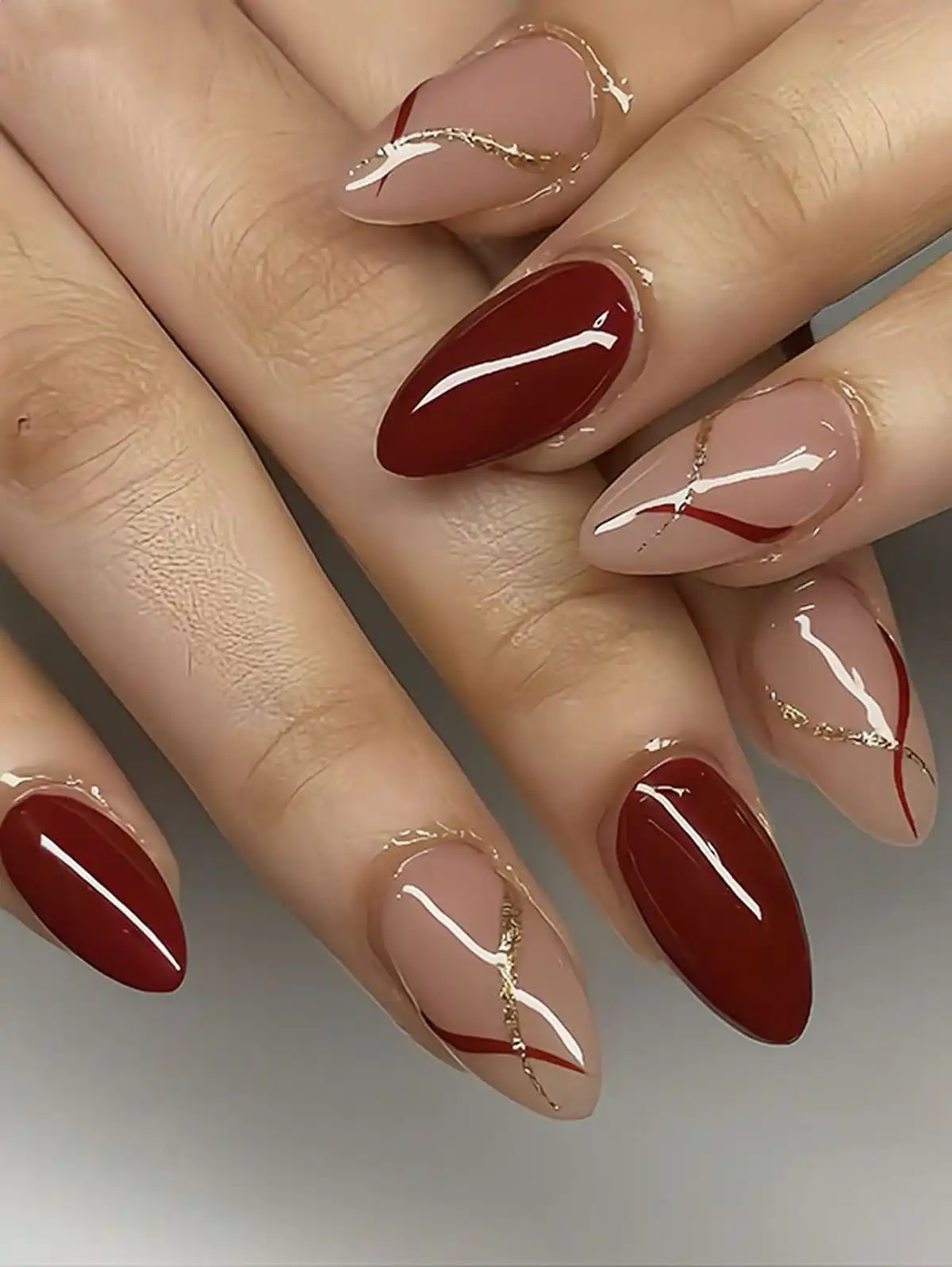 Nude-and-maroon diagonals with fine gold line accents