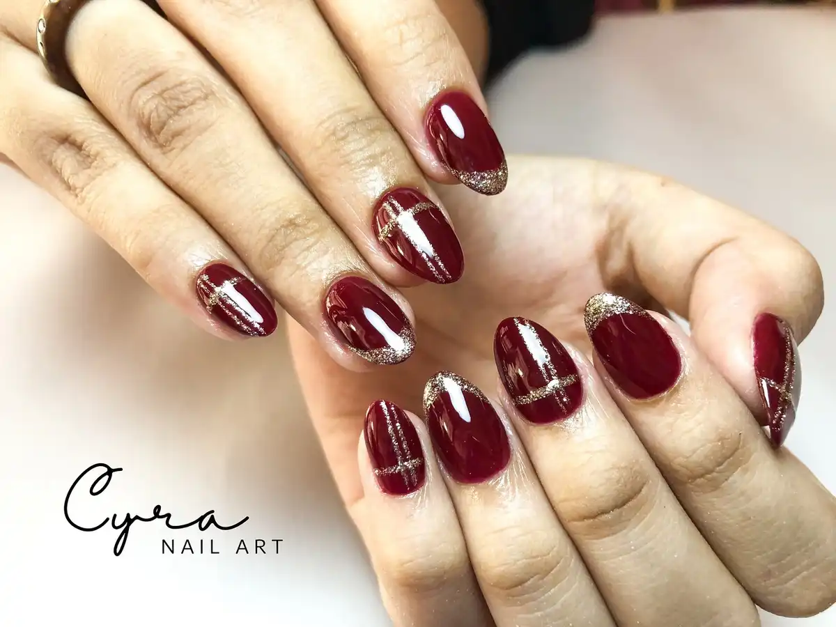 Deep maroon with gold glitter French tips and striping
