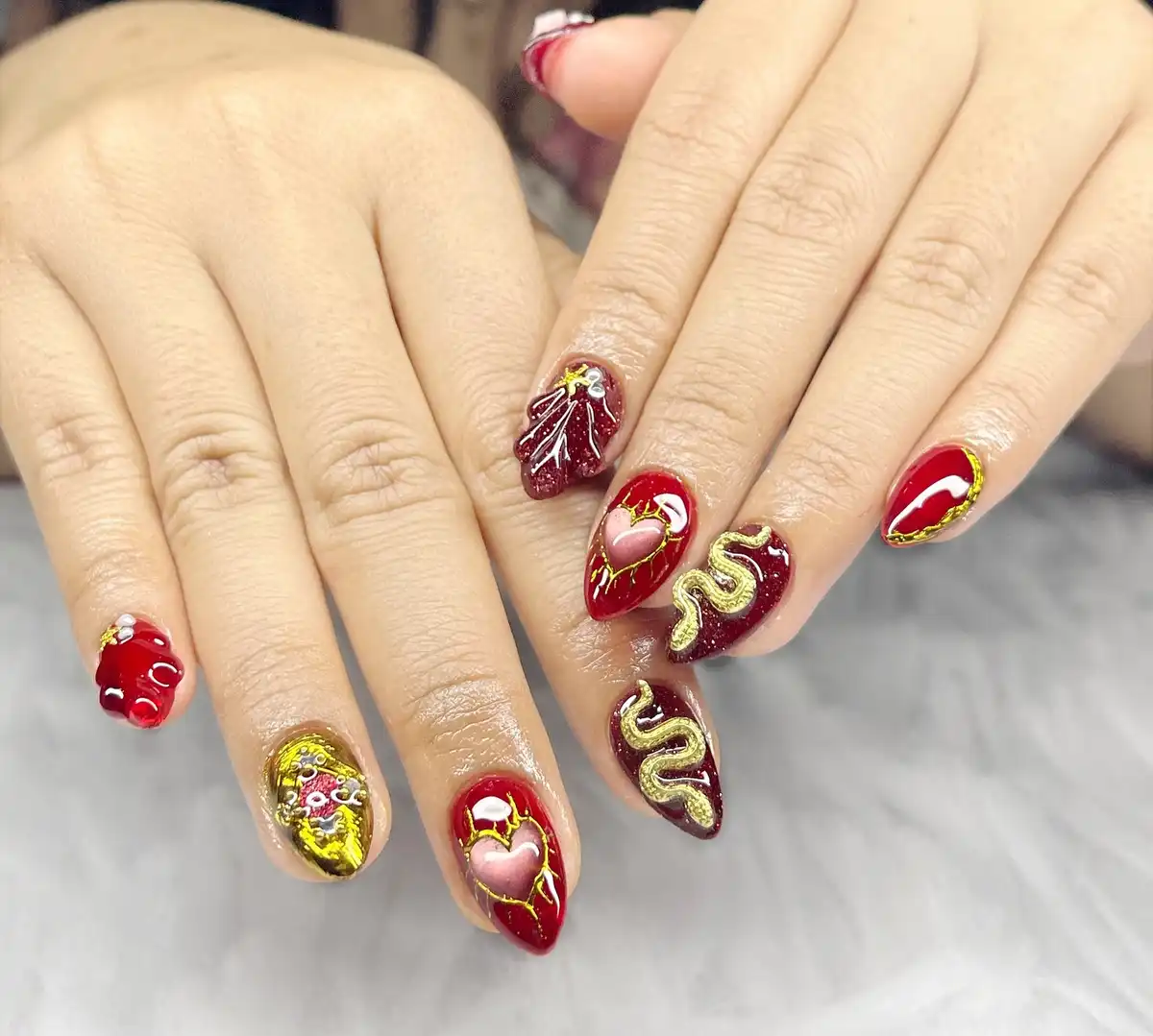 3D gold accents on red and maroon glitter stilettos