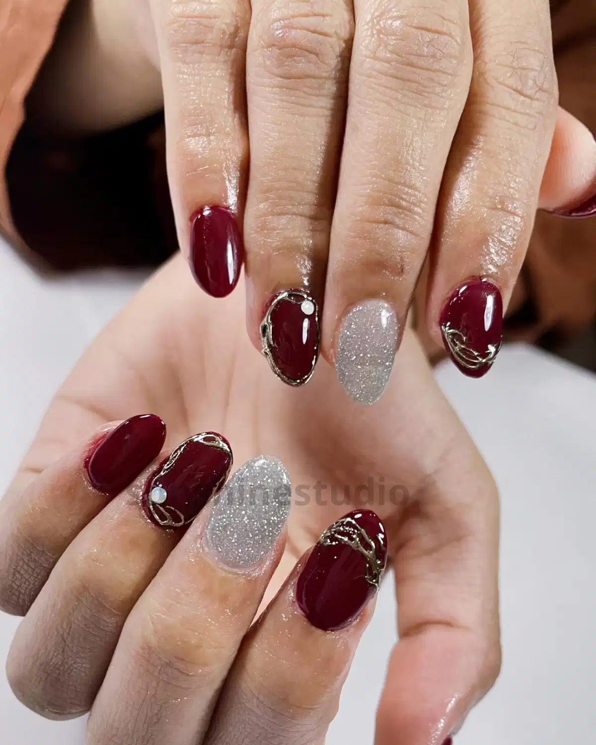 Maroon and Silver Glitter Nails with Gold Framing and Pearl Studs