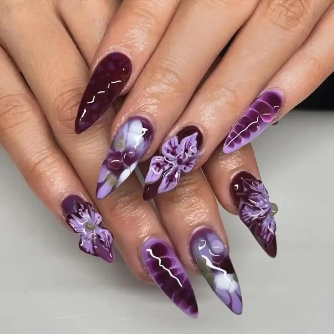 Deep plum stiletto nails with purple floral accents