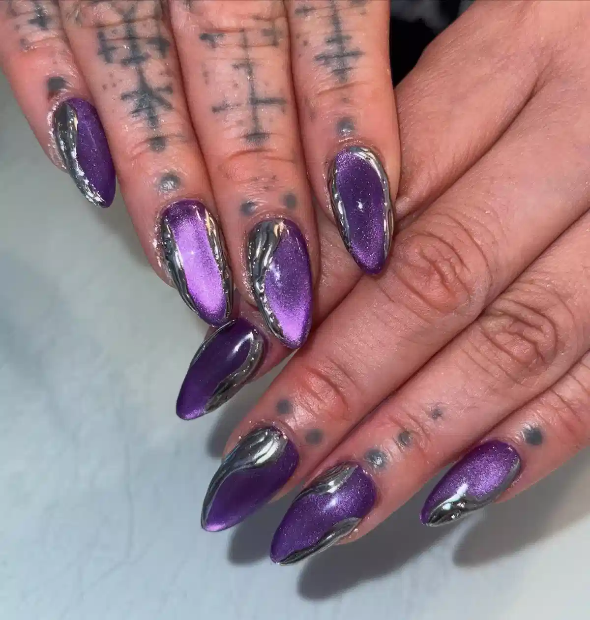 Purple metallic nails with raised silver wavy edging