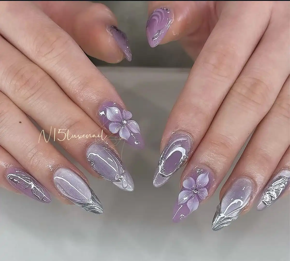 Grey-lilac translucent nails with silver accents and 3D lilac flowers