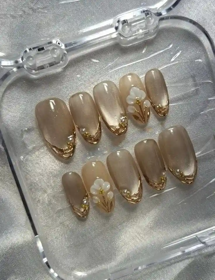 Taupe nails with gold tip borders and white 3D floral accents