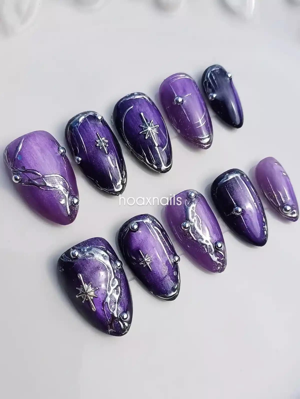 Purple press-on set with silver stars, studs, and raised lines