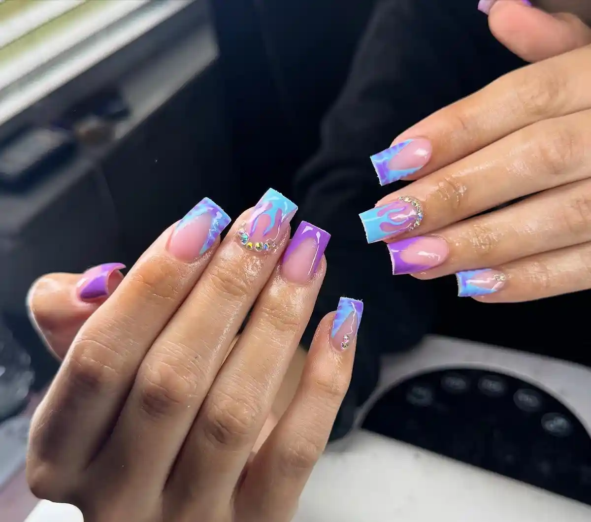 Nude square nails with blue/purple flames and rhinestones