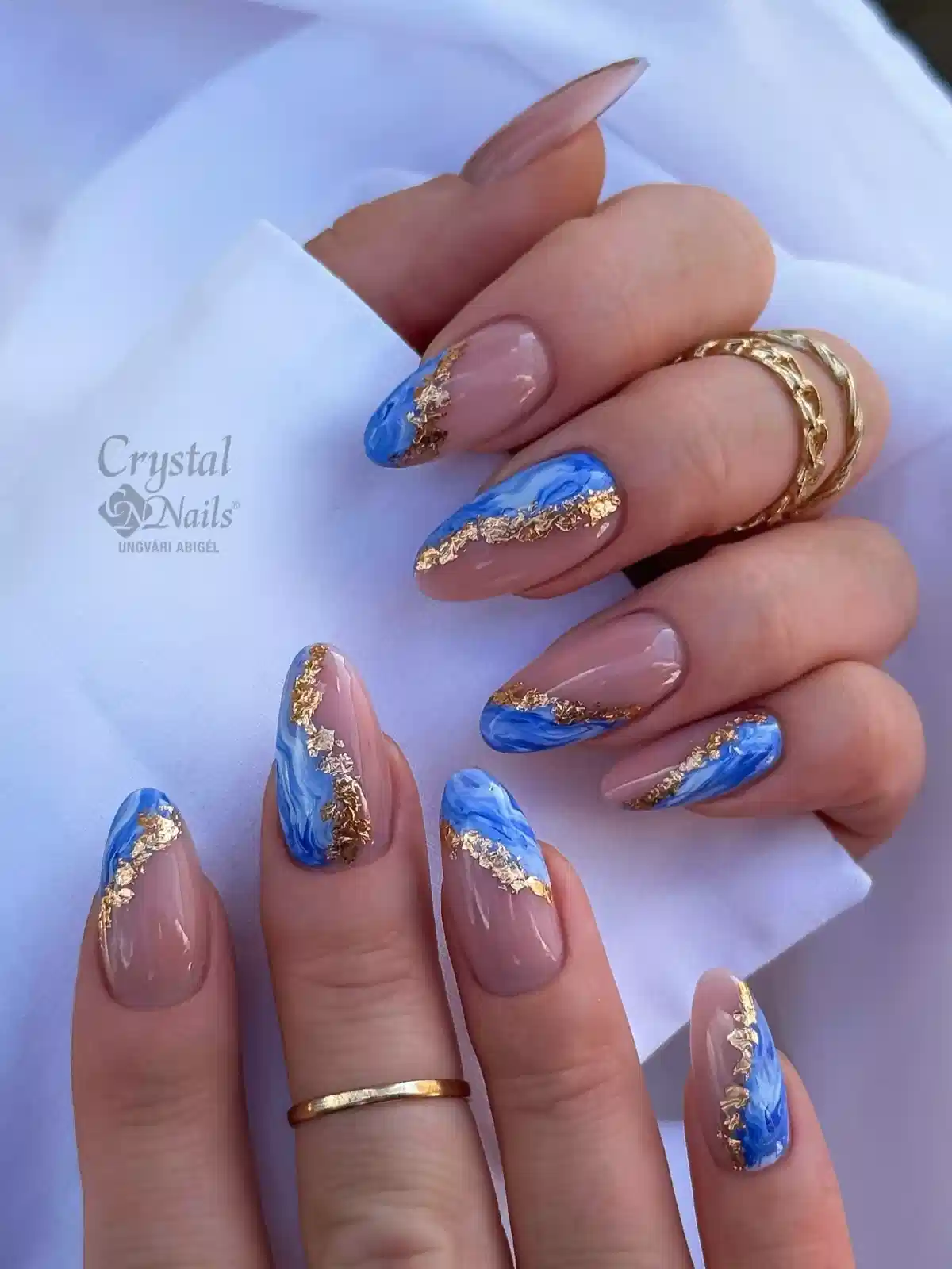 Nude almond nails with blue marble and gold edging