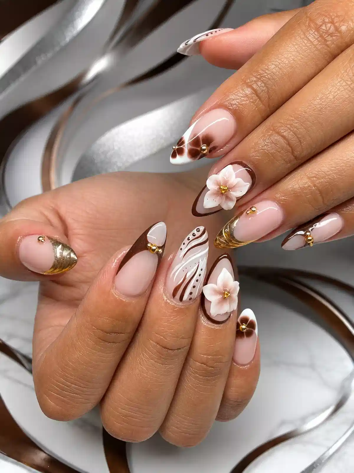 Brown-outlined French tips with 3D white flowers and gold accents