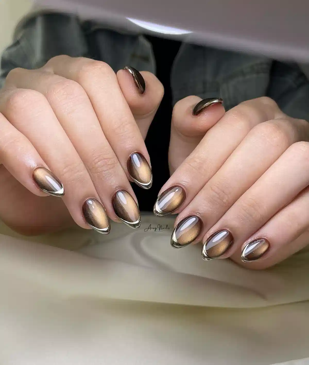 Framed bronze cat-eye nails with metallic perimeter outline