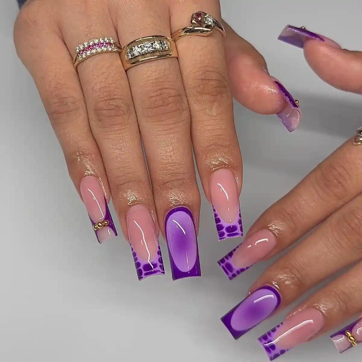 Nude-and-purple French tips with spotted accents and gold beads