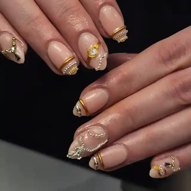 Nude glossy nails with gold striping and bead accents