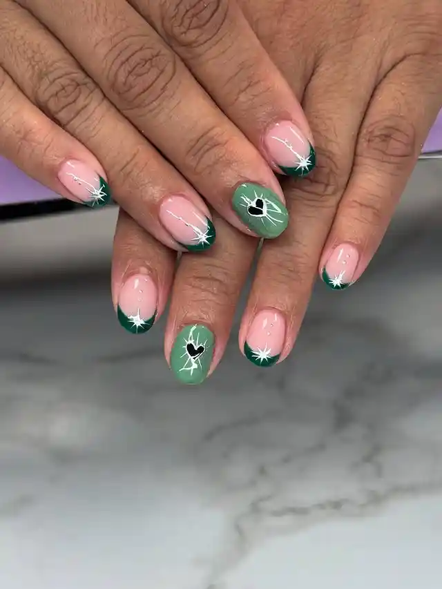 Green French tips with white starbursts and black hearts