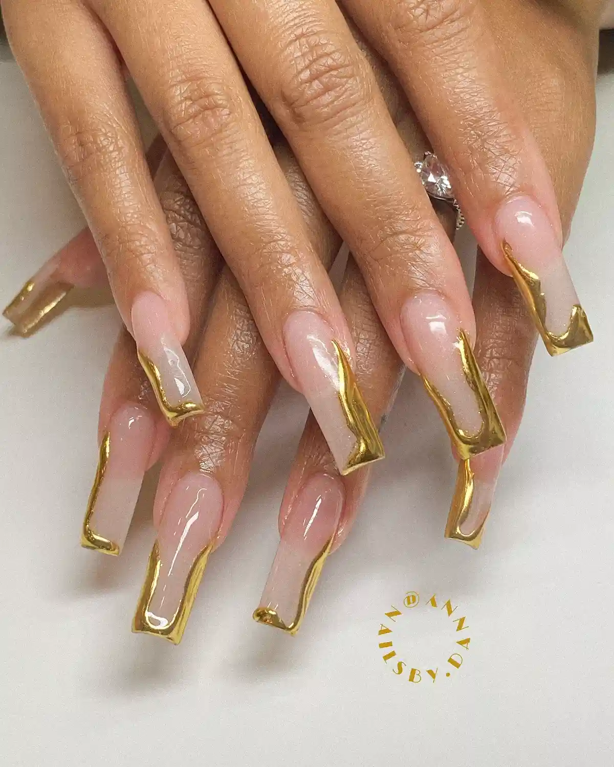 Long nude nails with metallic-gold framed edges