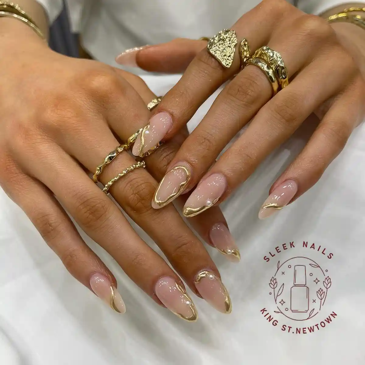 Gold-Edged Almond Nails with Wavy Accents and Beads