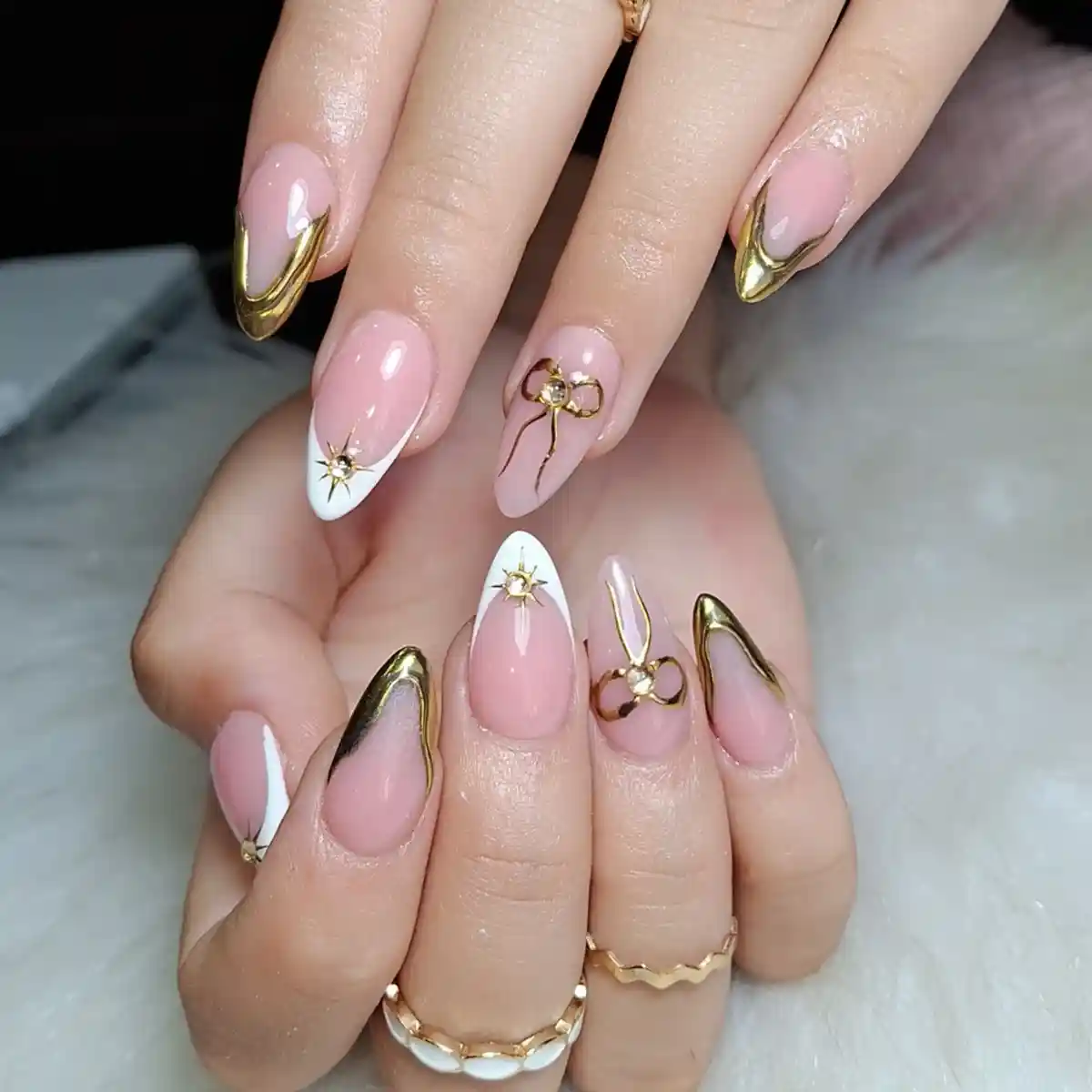 Pink Almond Nails with Gold V-Tips and Star Accents
