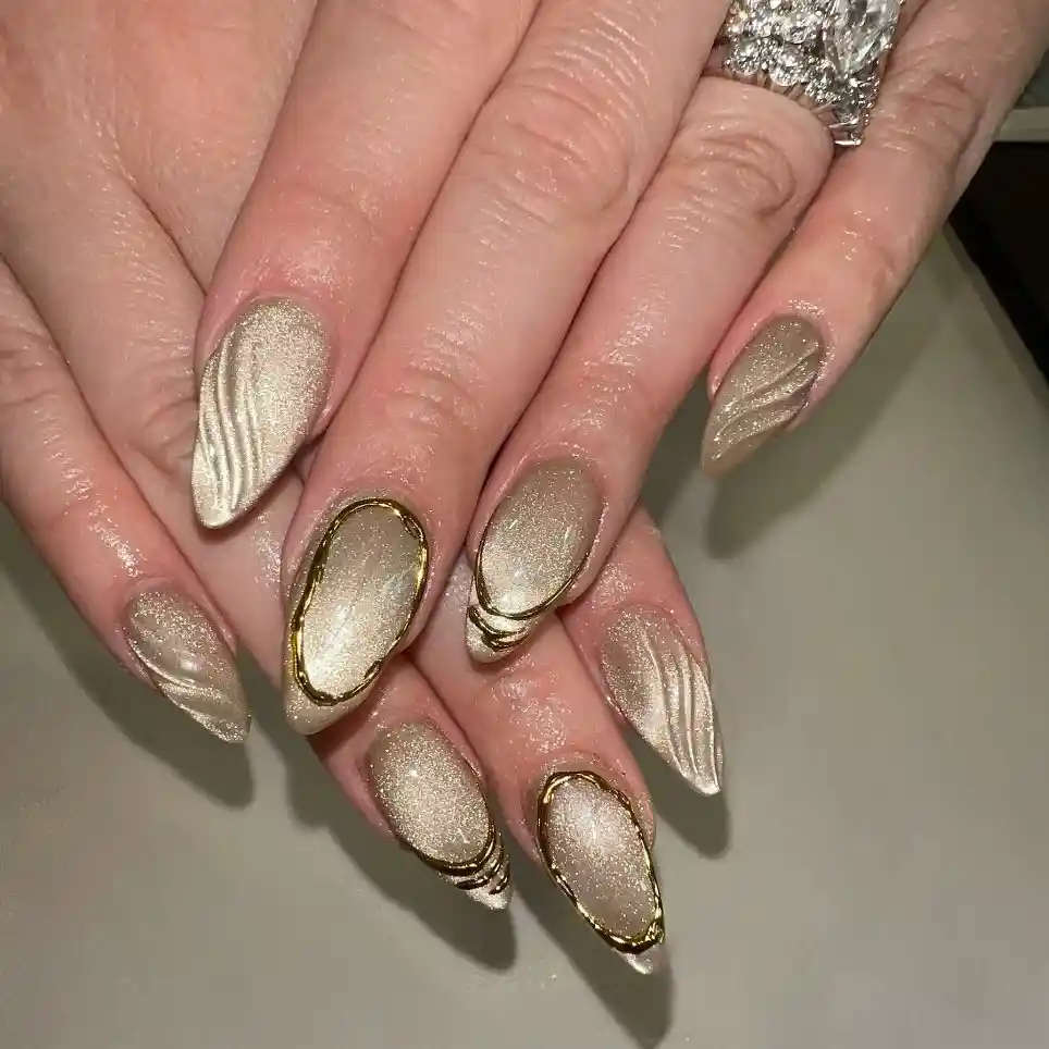 Champagne shimmer nails with raised waves and gold outlines