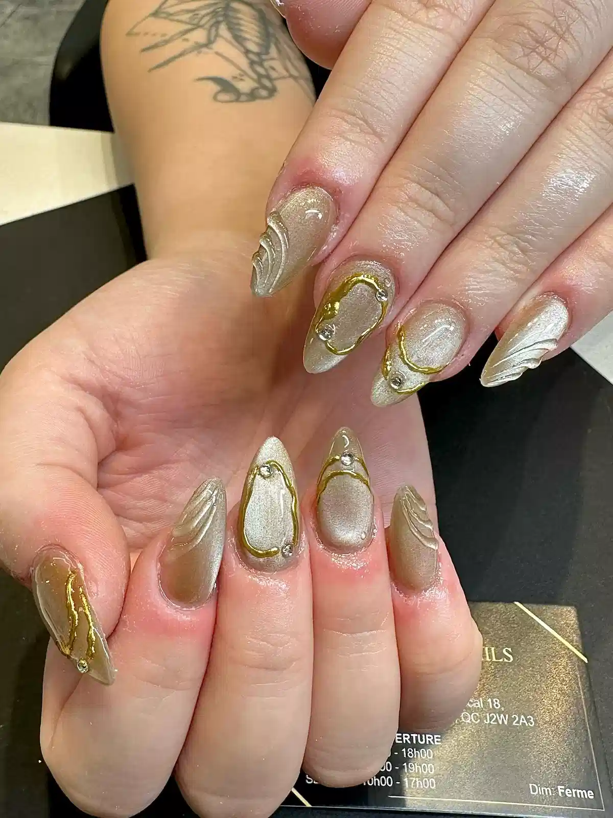 Metallic champagne nails with raised waves and gold outlines