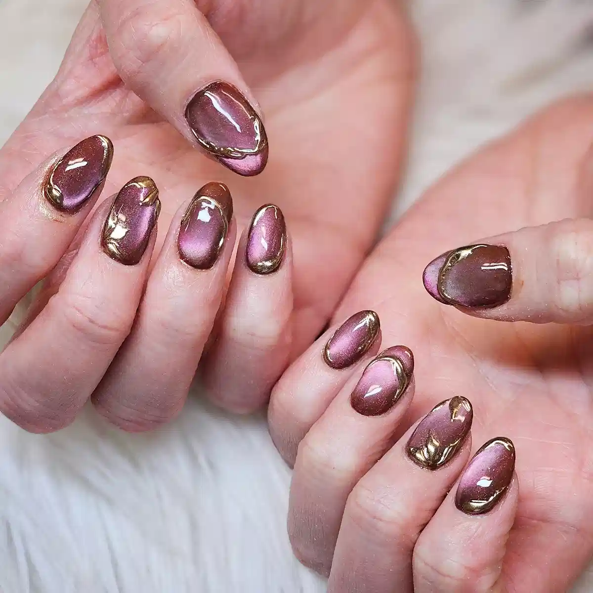 Brown-to-purple glossy nails with gold metallic outlines