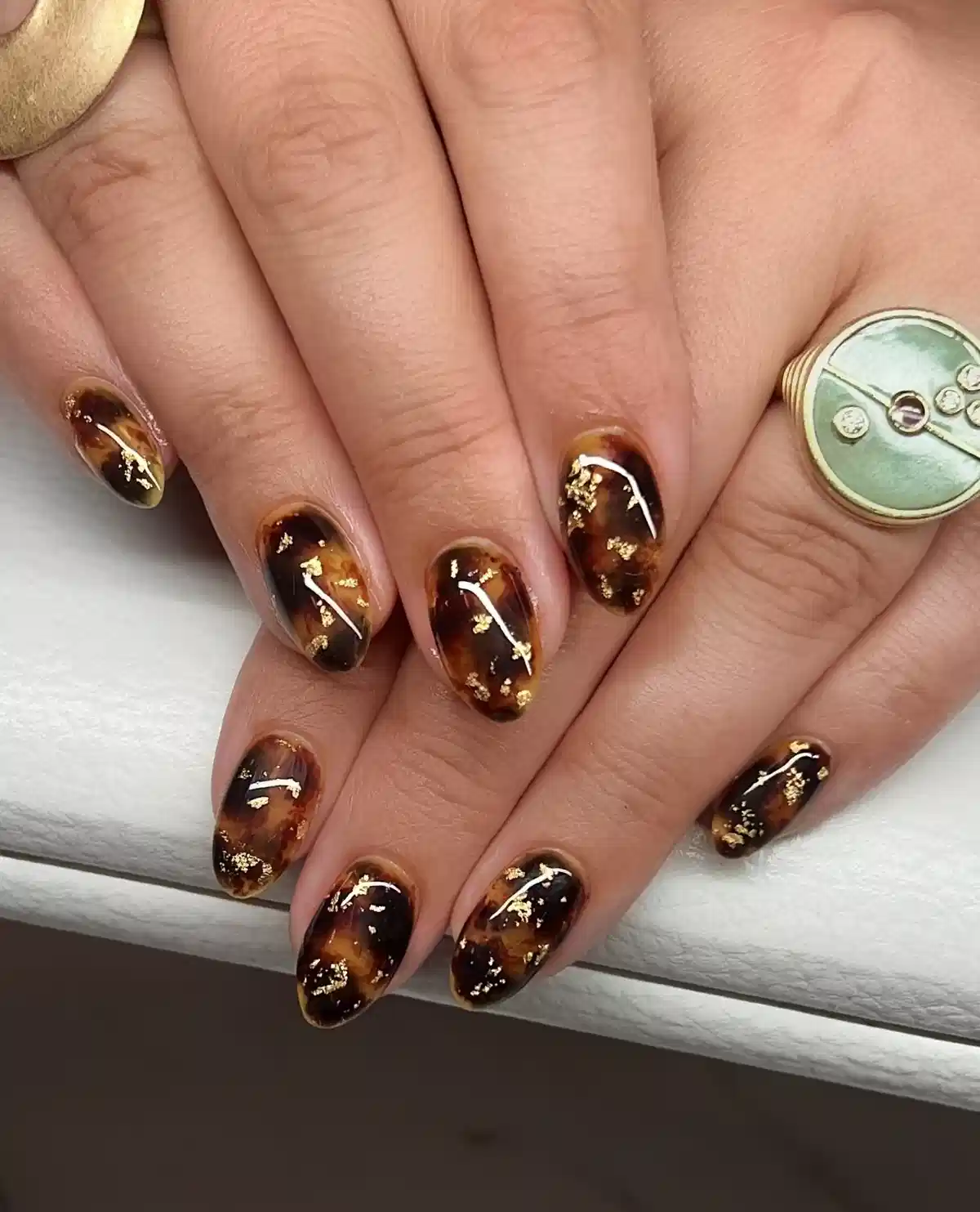 Amber-brown mottled nails with scattered gold accents