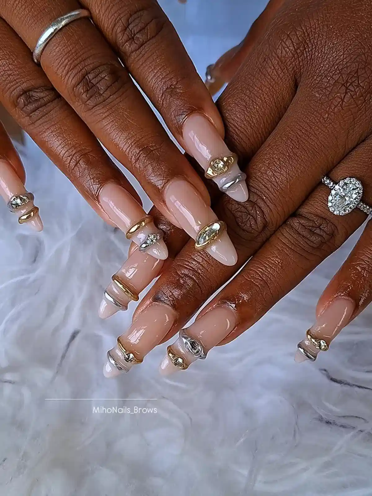 Nude long nails with raised metallic band accents